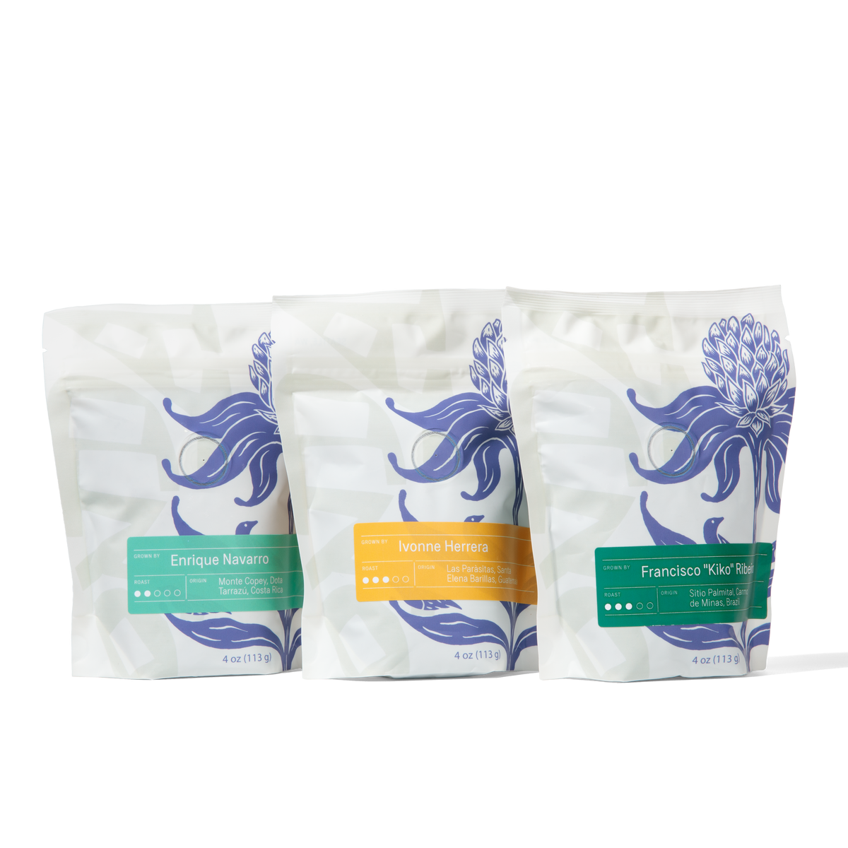 Three coffee bags with floral designs on a white background